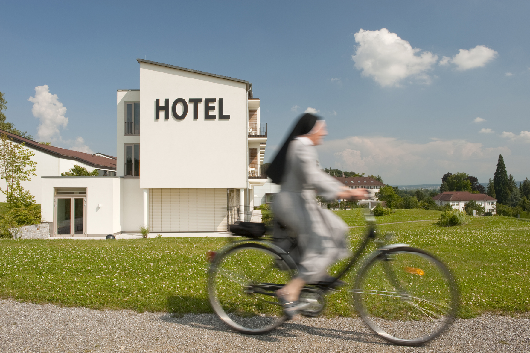 eine Frau fahrradfahrend vor dem Hotel Hegne