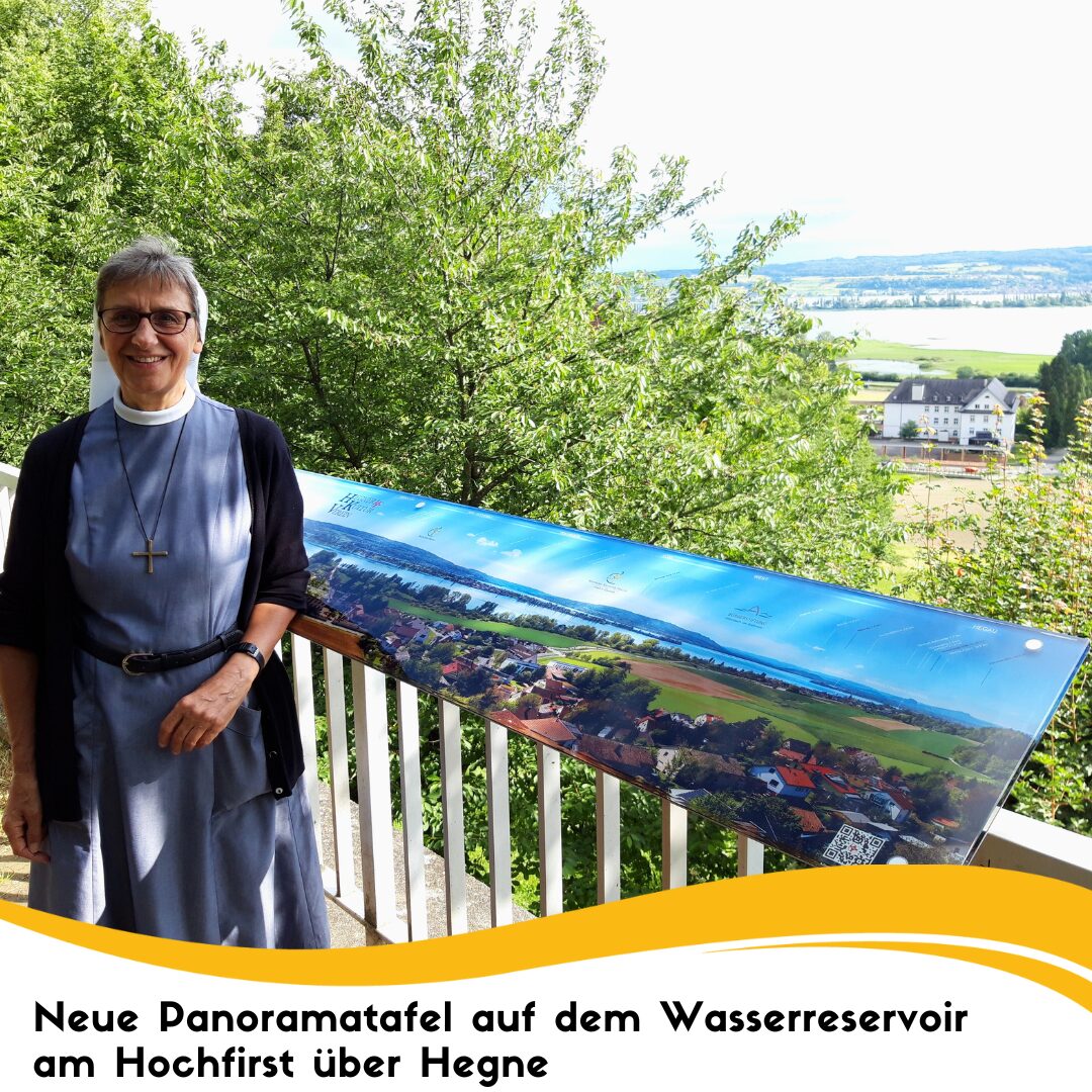 eine Frau steht vor der neuen Panoramatafel auf dem Wasserreservoir am Hochfirst über Hegne